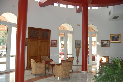 une chambre avec des chaises, une table et quelques fenêtres dans l'établissement Hotel Castillo, à Palma del Río