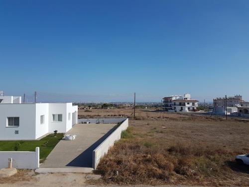 a white house with the ocean in the background at Flora Aparts in Dherinia