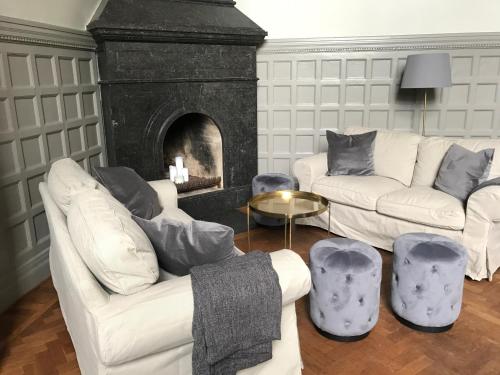 a living room with two white couches and a fireplace at Hotell Humbla in Sölvesborg