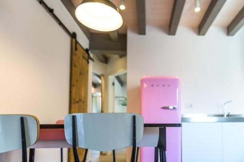 a room with three chairs and a pink appliance at Casa Kaki in Malcesine