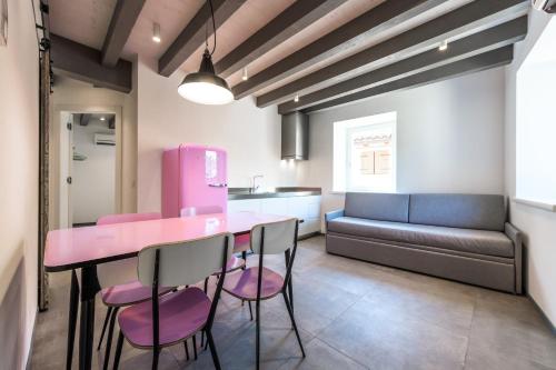 a pink table and chairs in a room with a couch at Casa Kaki in Malcesine