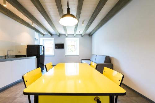 a conference room with a yellow table and chairs at Casa Kaki in Malcesine