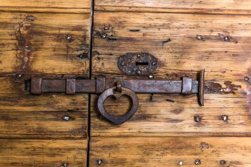 an old door latch with a heart on a wooden door at Casa Kaki in Malcesine