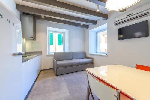 a living room with a couch and a kitchen at Casa Kaki in Malcesine