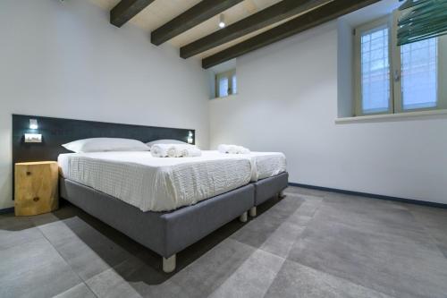 a bedroom with a large bed with white sheets at Casa Kaki in Malcesine