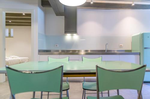 a dining room with a green table and chairs at Casa Kaki in Malcesine
