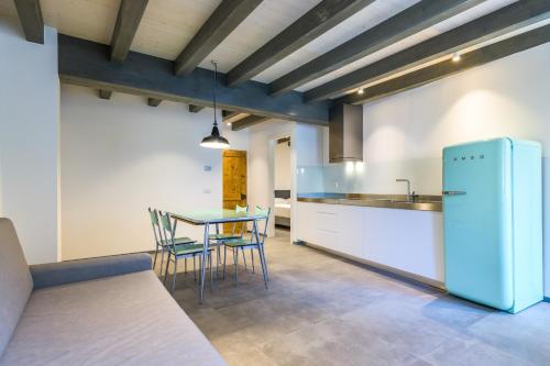 uma cozinha com uma mesa e um frigorífico azul em Casa Kaki em Malcesine