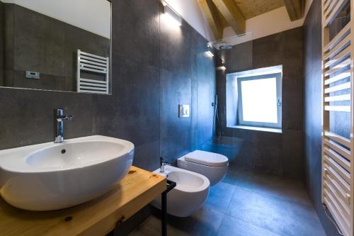 a bathroom with a white sink and a toilet at Casa Kaki in Malcesine