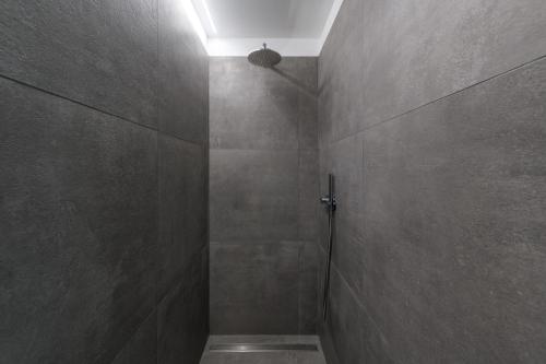 a bathroom with a shower with a light on the wall at Casa Kaki in Malcesine