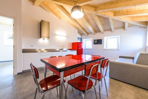 a kitchen and dining room with a red table and chairs at Casa Kaki in Malcesine