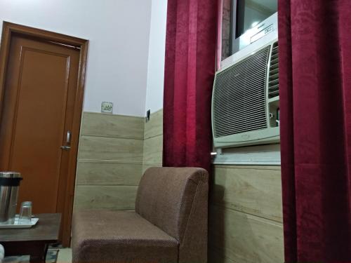 a living room with a chair and a microwave at Hotel Palace in Amritsar
