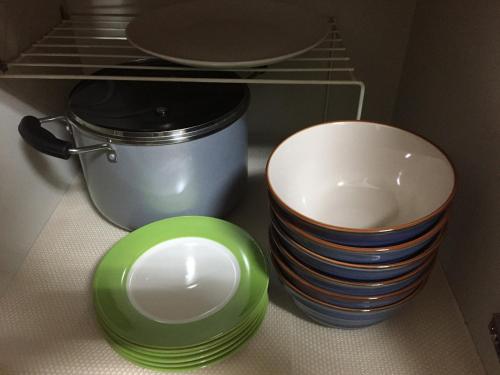 a stack of plates and bowls sitting on a shelf at Fukuoka Condominium in Fukuoka
