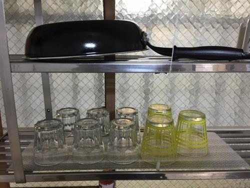 a bunch of glasses sitting on a shelf at Fukuoka Condominium in Fukuoka