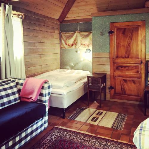 a bedroom with a bed and a couch in a room at Klefstad gård in Linghem