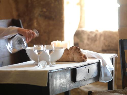 a person is pouring wine into glasses on a table at Sextantio Le Grotte Della Civita in Matera
