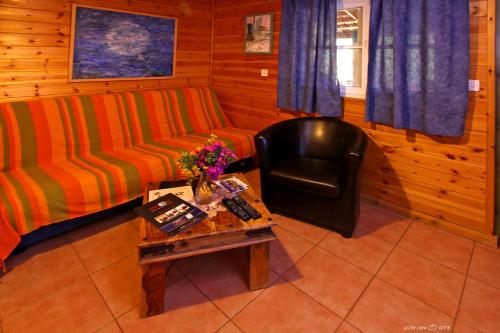 a living room with a couch and a chair and a table at Nof Kinneret Cabins in Had Nes