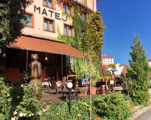a building with a table and chairs in front of it at Hotel & Penzión Grand Matej in Banská Štiavnica