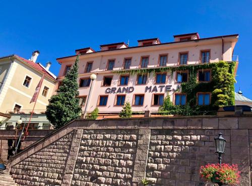 a building with a sign on the side of it at Hotel & Penzión Grand Matej in Banská Štiavnica