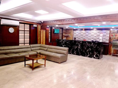 a living room with couches and a table at Hotel Chetan International in Bengaluru