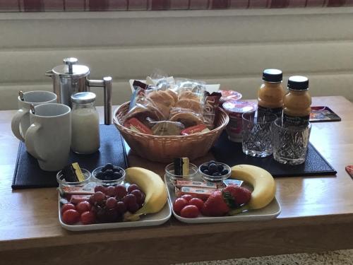 奧本的住宿－Gramarvin B&B，一张桌子,上面放着两个盘子的食物和一篮水果