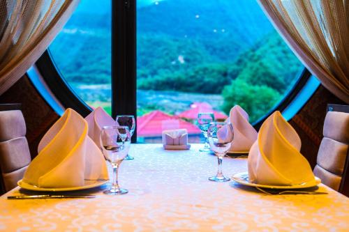 a table with wine glasses and napkins on it at Bergs Hotel And Restaurant in Qax