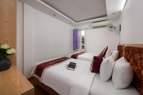 a hotel room with a bed with a book on it at Hanoi Fantasea Hotel in Hanoi