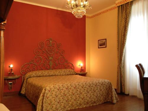 a bedroom with a bed with a red wall at La Dependance in Menaggio