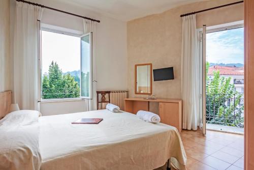 pokój hotelowy z łóżkiem i dużym oknem w obiekcie Albergo Rondò w mieście Acqui Terme