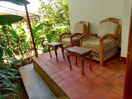a room with two chairs and a table on a patio at Bushbaby Lodge in Mukono