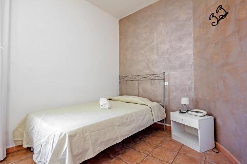 a bedroom with a bed and a night stand with a phone at Albergo Rondò in Acqui Terme