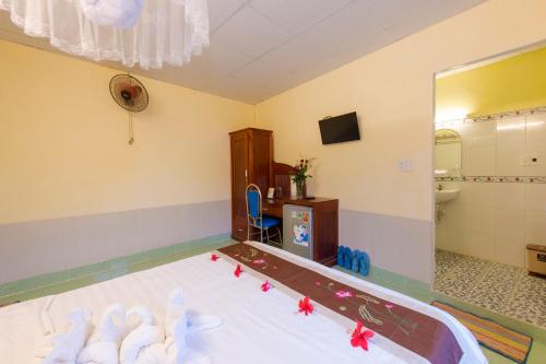 a bedroom with a bed and a bathroom with a mirror at Bougain Villeas Homestay in Hoi An