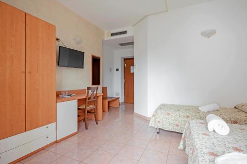 a hotel room with a bed and a dining room at Albergo Rondò in Acqui Terme