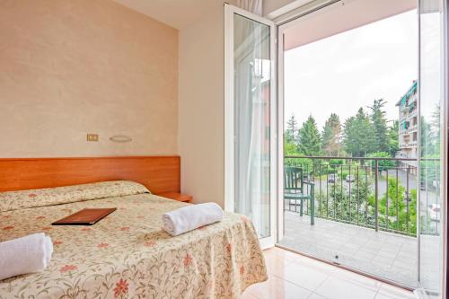 a bedroom with a bed and a large window at Albergo Rondò in Acqui Terme
