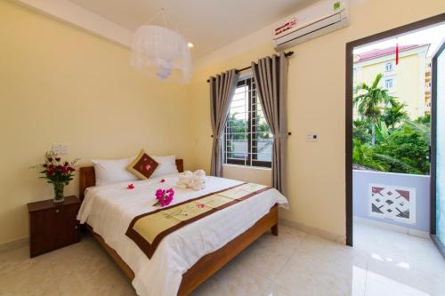 a bedroom with a large bed with flowers on it at Bougain Villeas Homestay in Hoi An