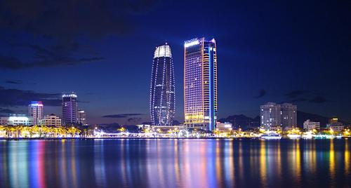 a city skyline at night with the water and buildings at Mama Hotel And Apartment - Free Sauna And Gym in Da Nang
