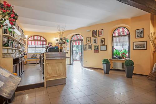 a restaurant with a lobby with yellow walls and windows at Albergo Rondò in Acqui Terme