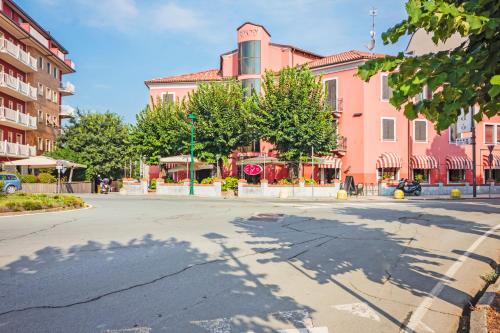 an empty street in front of a pink building at Albergo Rondò in Acqui Terme