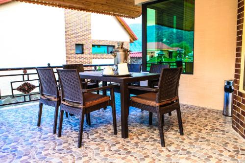 a dining room table and chairs on a patio at Bergs Hotel And Restaurant in Qax