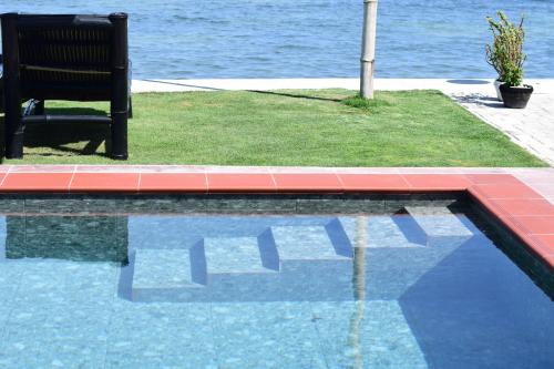 a bench sitting next to a pool of water at the beachhouse in Dalaguete