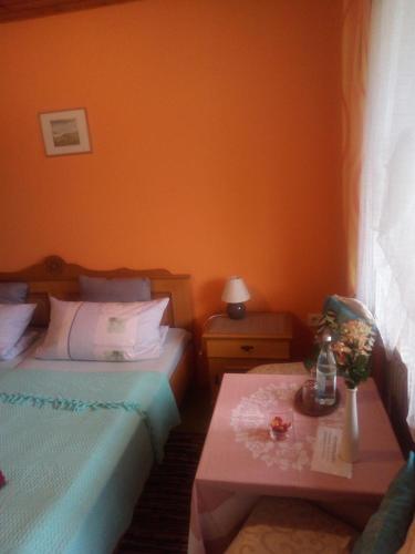 a hotel room with two beds and a table at Pension Waldblick in Spiegelau