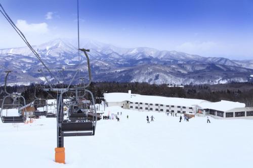 un grupo de personas en un remonte en la nieve en Hotel Alpen Blick, en Myoko