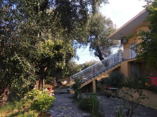 a house with a staircase next to a yard at Barbara's Sea View Home in Benitses