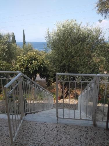 a gate to a garden with the ocean in the background at Barbara's Sea View Home in Benitses