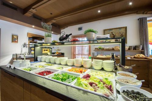 a buffet line with many different types of food at Hotel Babymio in Kirchdorf in Tirol