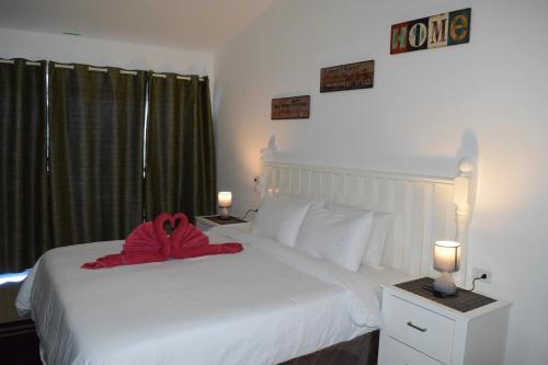 a bedroom with a white bed with a red towel on it at the beachhouse in Dalaguete