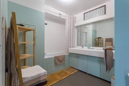 une salle de bain avec un lavabo et un miroir dans l'établissement Appartement Lyon Centre Confluence 100 m2 Parking Terrasses, à Lyon