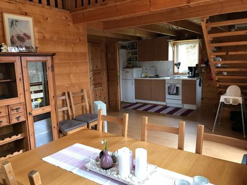 a dining room and kitchen in a log cabin at Örnatorpet Ullared in Ullared
