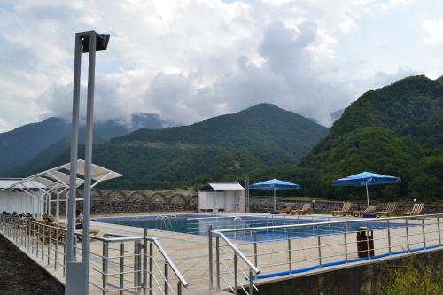 a swimming pool with mountains in the background at Bergs Hotel And Restaurant in Qax