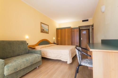 a bedroom with a bed and a couch and a table at Hotel Lido in Gargnano