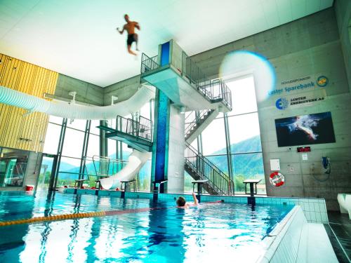 una piscina con una persona saltando de un tobogán de agua en Gaupnetunet Hotell og Hytter en Gaupne